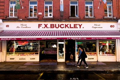 A man and a woman walk in F.X.B uckley shop before

